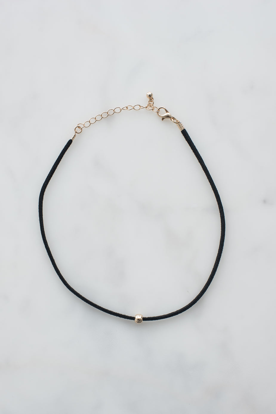 Black cord choker necklace with gold bead accent and adjustable chain clasp on white background.