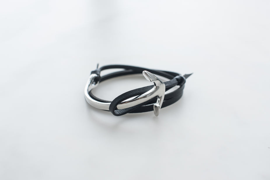 Black leather anchor bracelet for men with silver metal hook clasp on white background