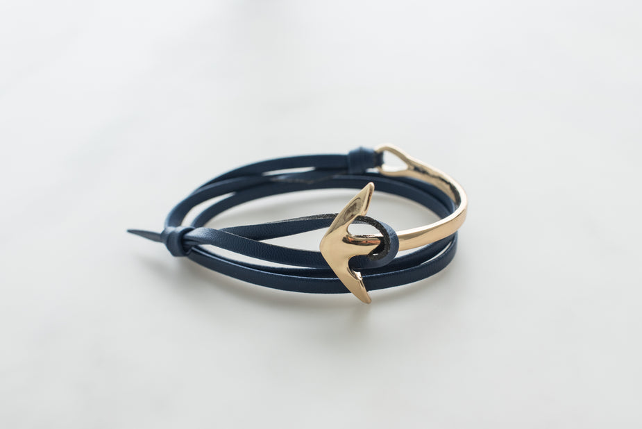 Navy leather anchor bracelet for men with gold-tone hook clasp on white background