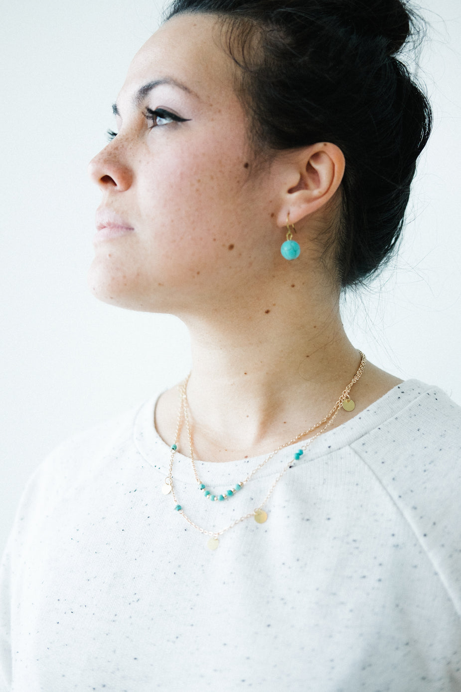 Turquoise boho earrings on model, gold chain necklaces, minimalist jewelry style