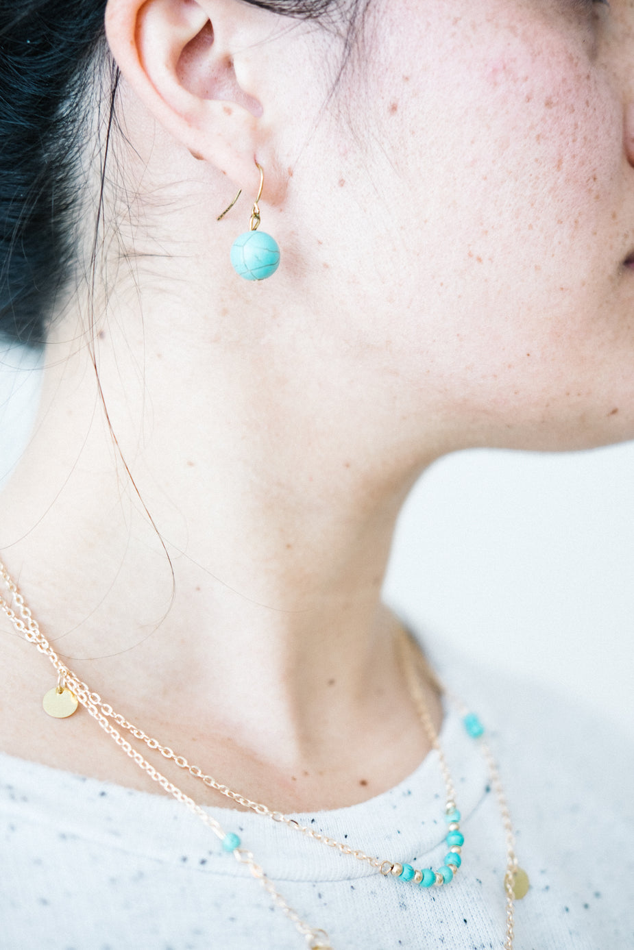 Turquoise boho earrings with gold hooks worn on model, showcasing delicate sphere design and coastal style jewelry aesthetic.