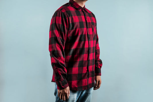 Men's red and black chequered shirt with long sleeves, button-front closure, displayed on model against neutral background.