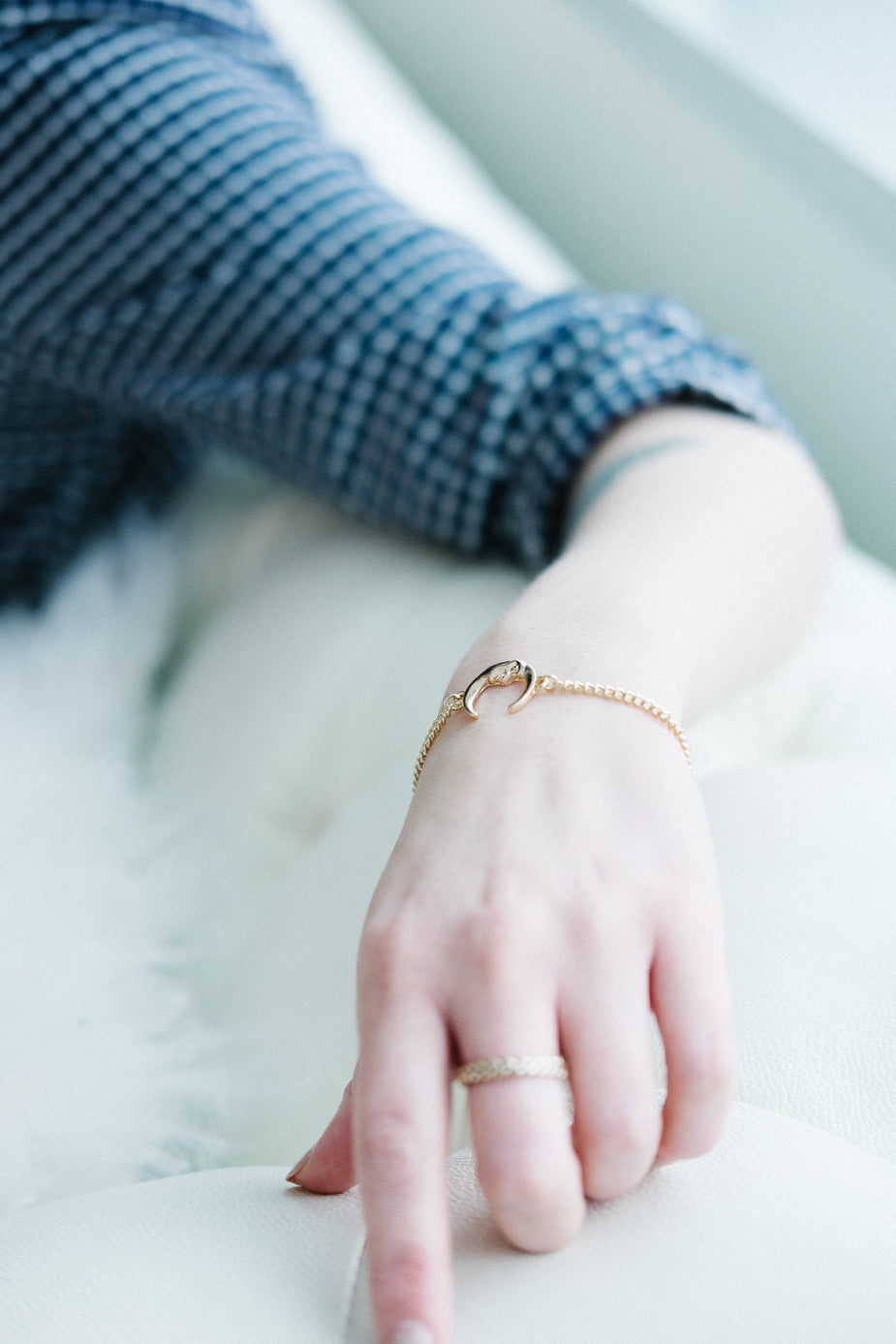 Moon Charm Bracelet in gold worn on woman's wrist with matching band ring