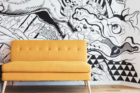 Modern yellow sofa with wooden legs against black and white abstract mural wallpaper in contemporary living room interior design.